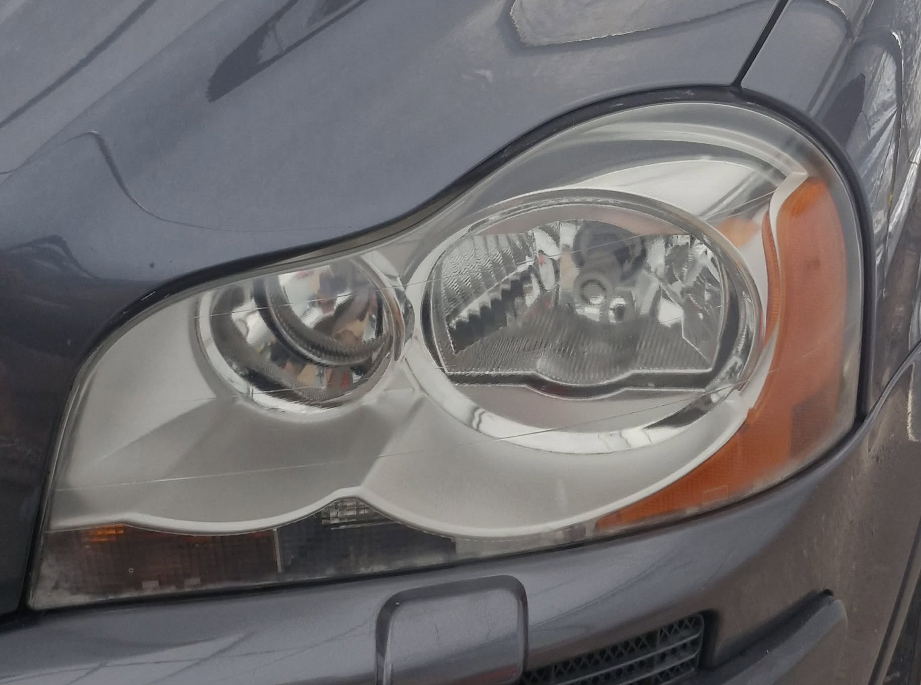 Close-up of an oxidised headlight lens before restoration by Tailored Detail
