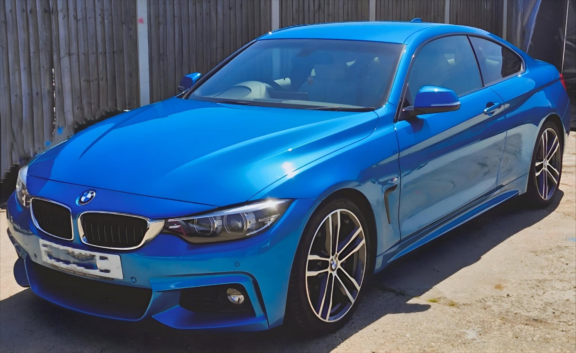 Bright blue BMW 4 Series M Sport under studio LED lighting during paint correction at Tailored Detail, Hockley Essex